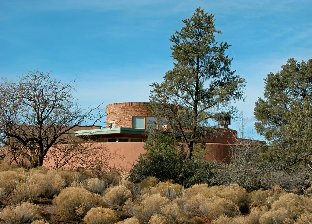 Southwestern-style home with stone tower and desert landscaping set in the Sedona terrain.