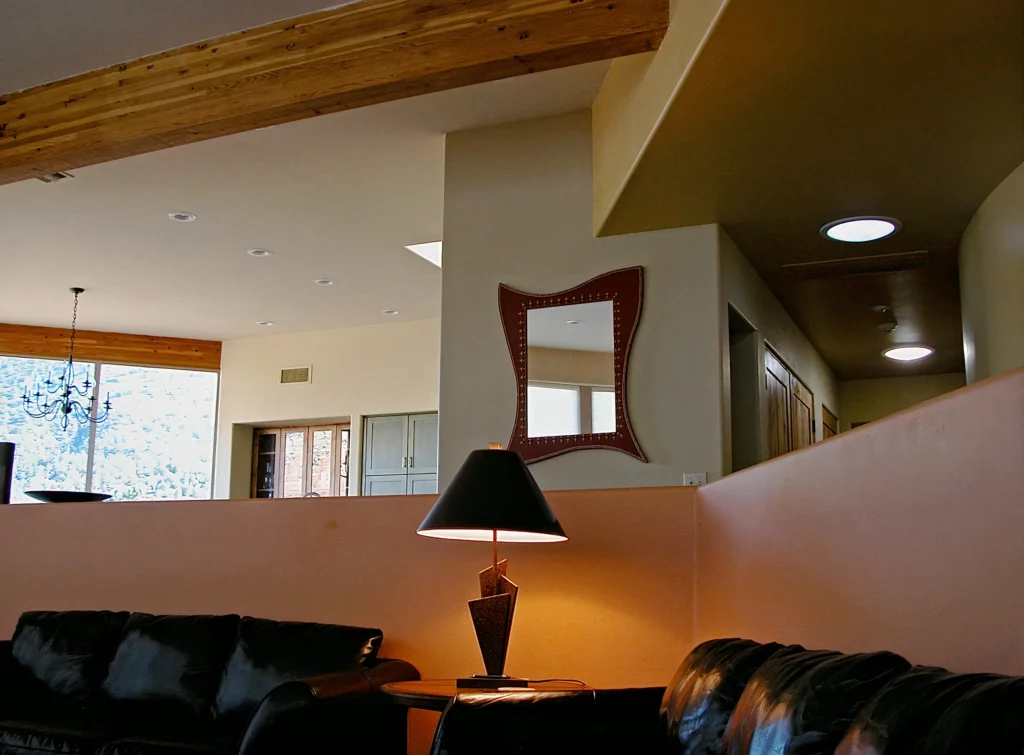 Front entry of the Sedona residence featuring a curved adobe wall and stone tower elements.