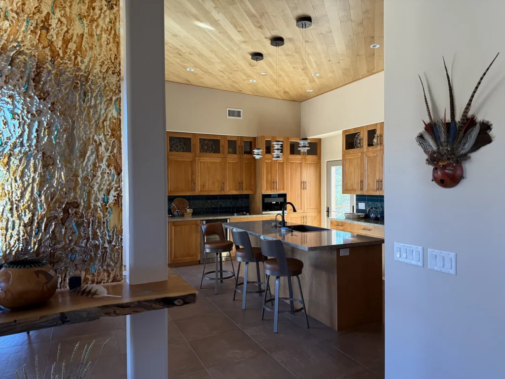 Kitchen with wood cabinetry, pendant lighting, and a textured glass accent panel.