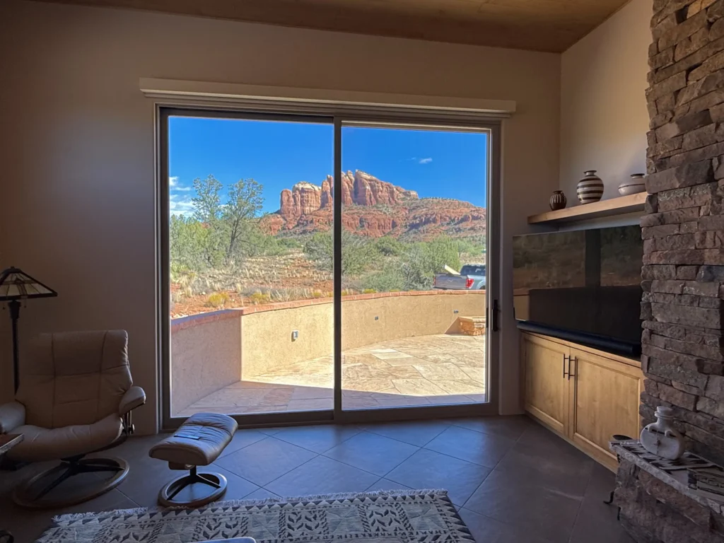 Beautiful room with sliding doors framing a panoramic view of Sedona’s Cathedral Rock.