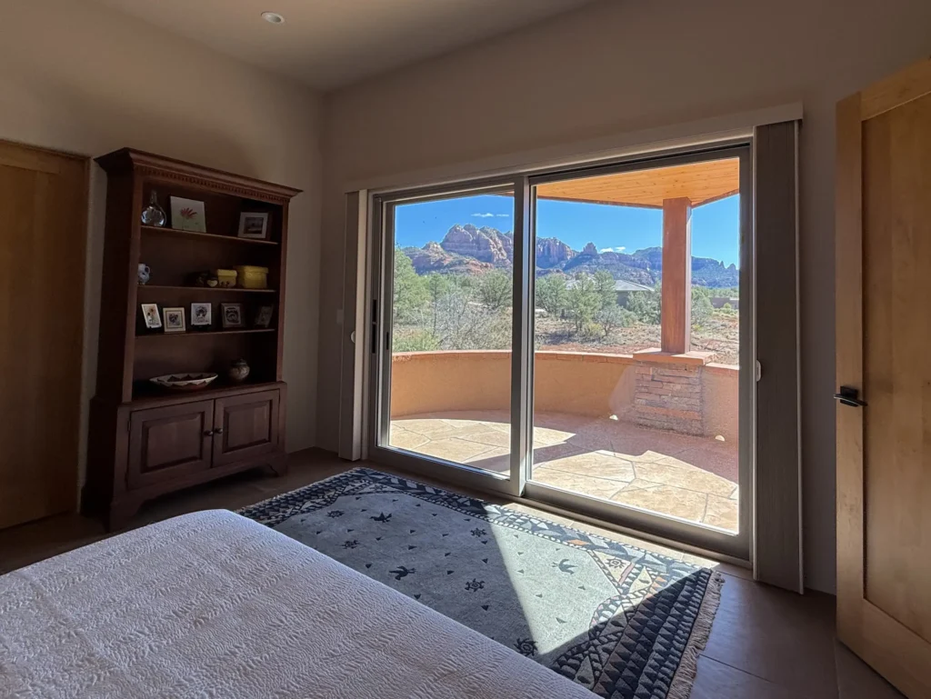 Bedroom with sliding glass doors opening to a patio and sweeping Sedona scenery.