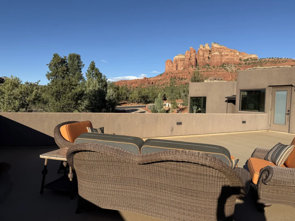 Roof terrace seating area with woven lounge chairs and sweeping views of Cathedral Rock.