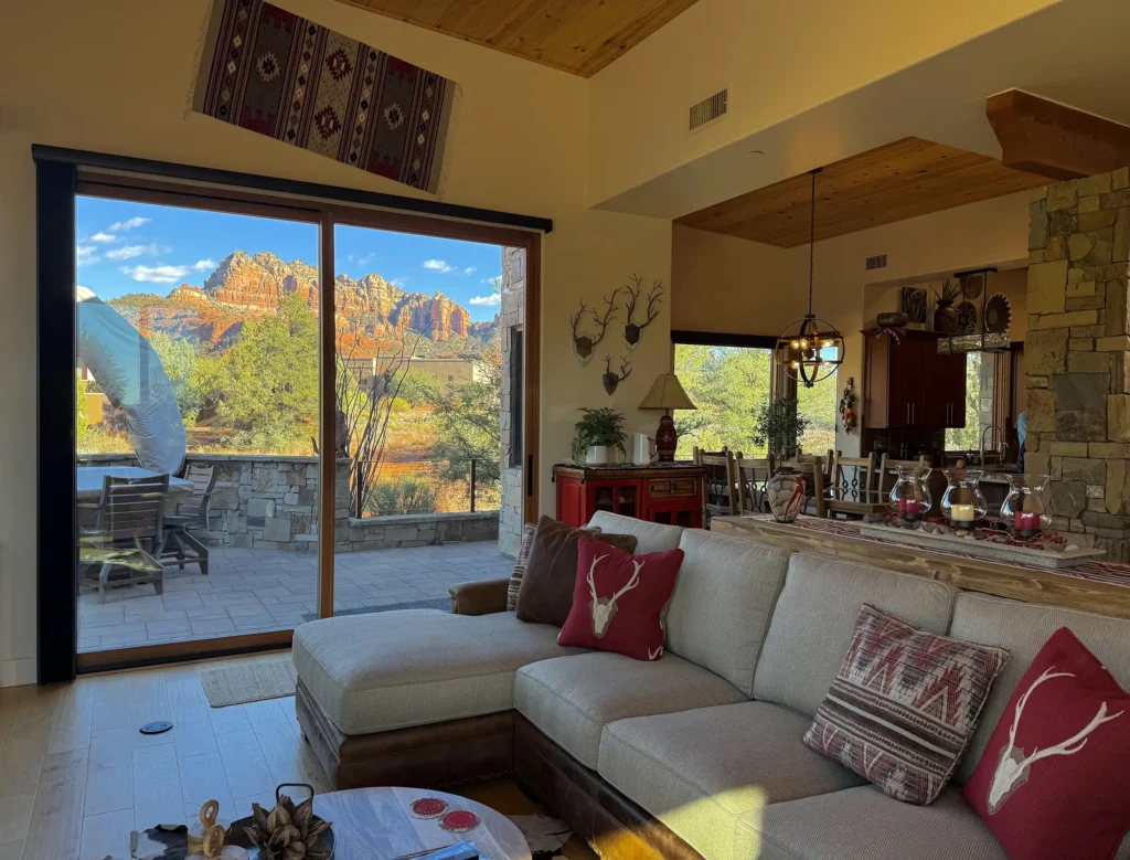 Living room with sectional sofa and sliding glass doors opening to a patio and red rock views.
