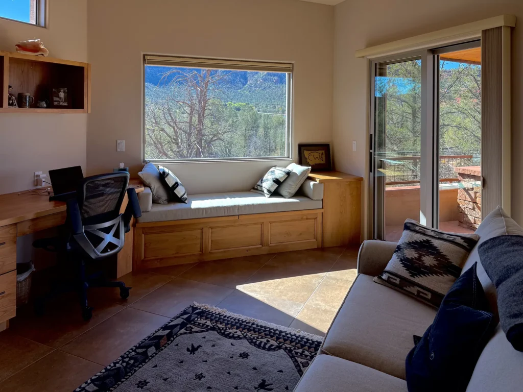 Home office with window seat and sliding door offering spectacular views.